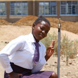 Ein Mädchen aus der Nansenga-Schule ist froh über das frische Trinkwasser.